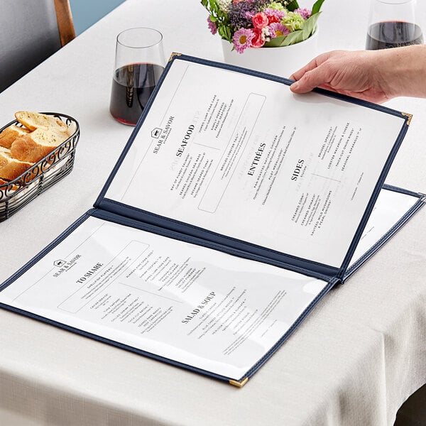 A hand holding a blue menu open on a table.