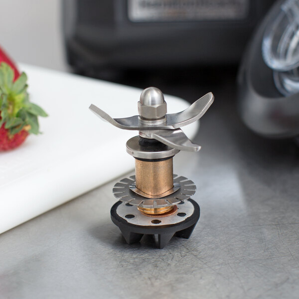 A Hamilton Beach commercial blender cutting assembly with a metal blade.