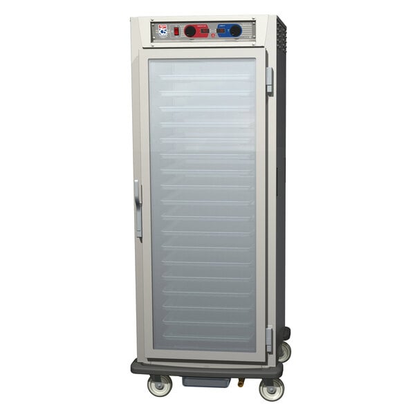 A stainless steel Metro C5 heated holding and proofing cabinet with clear doors on wheels.