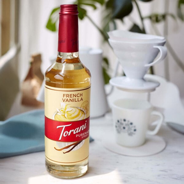 A Torani Puremade French Vanilla flavoring syrup bottle on a table.