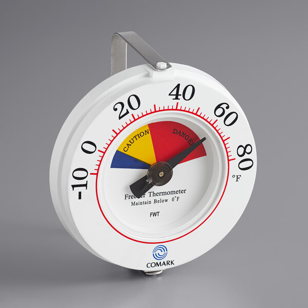 A white round Comark HACCP freezer wall thermometer with a red, yellow, and blue dial.