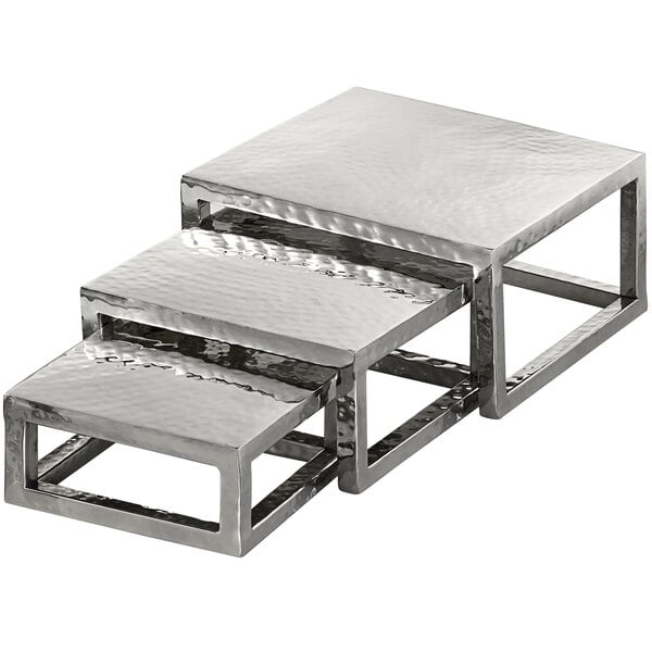 A stack of American Metalcraft silver metal square risers.