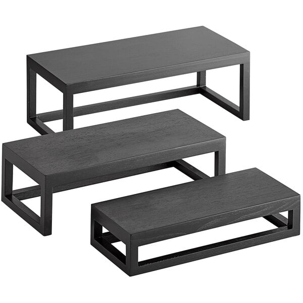 A black wood rectangular riser set on a black table.