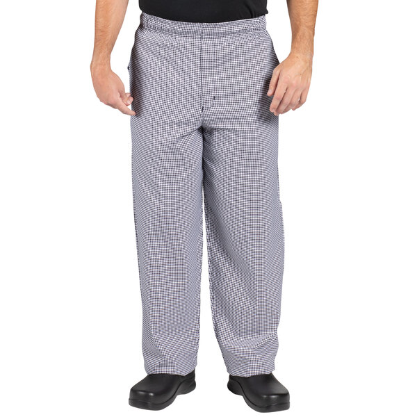 A person wearing Uncommon Chef houndstooth chef pants and a black shirt.