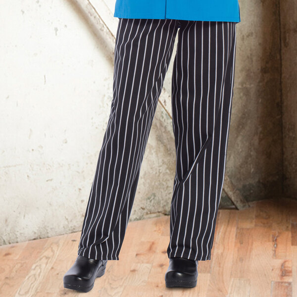 A person wearing Uncommon Chef black and white striped pants.