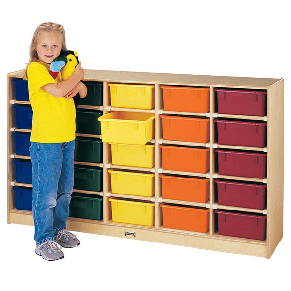 A young girl holding a stuffed animal next to a Jonti-Craft mobile wood storage cabinet with clear tubs.