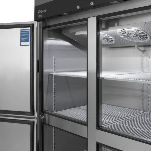 A white Turbo Air M3 Series reach-in refrigerator with open half doors showing shelves inside.
