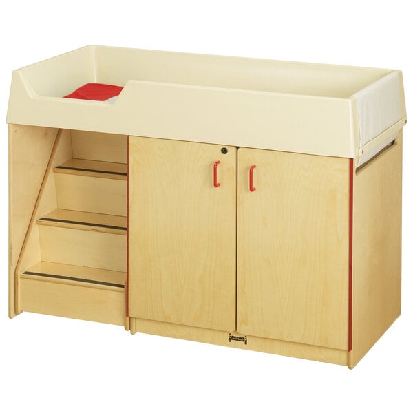 A Jonti-Craft wooden diaper changing cabinet with cubbie trays and a paper roll dispenser.