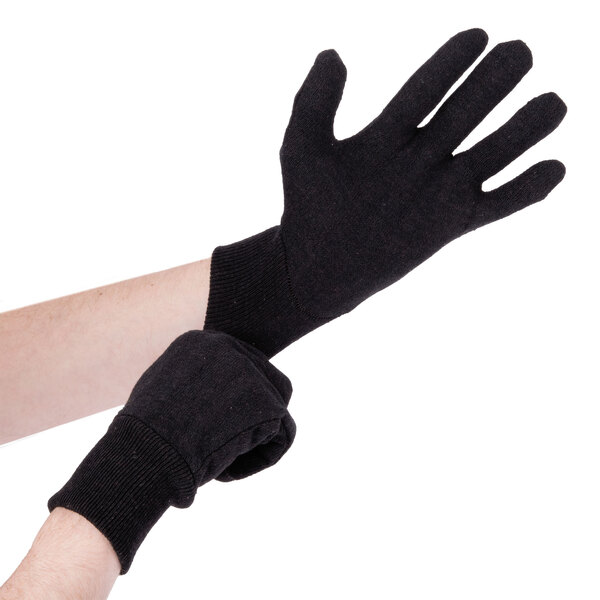 A pair of hands wearing Cordova brown jersey gloves.