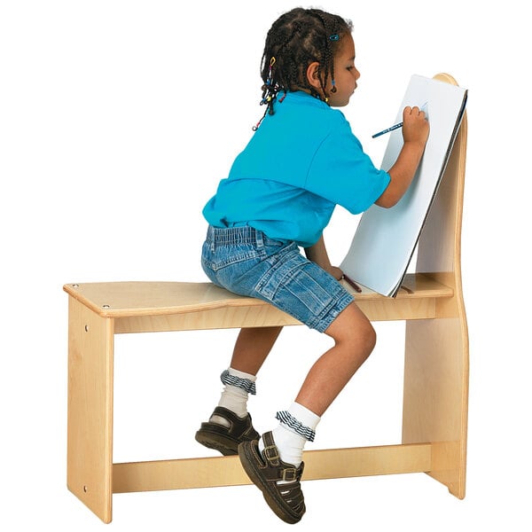 A child drawing on a Jonti-Craft wood art horse.