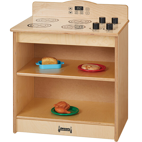 A Jonti-Craft wooden toy stove in a school kitchen.