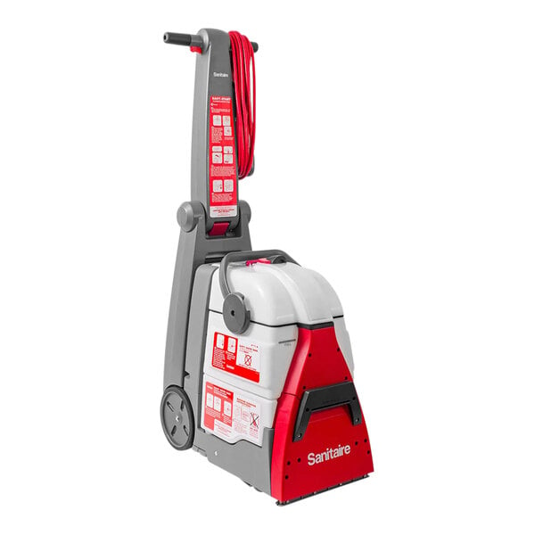 A Sanitaire upright carpet extractor with a red handle.