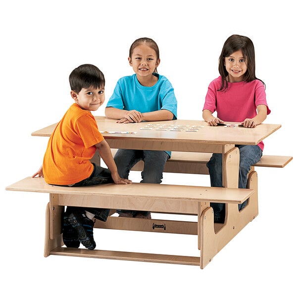 A group of children sitting at a Jonti-Craft wooden picnic table.