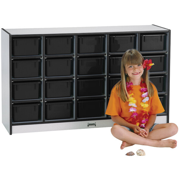 a girl sitting in front of a cabinet