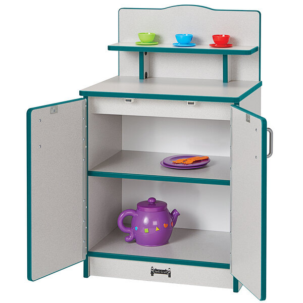A Rainbow Accents teal kitchen cupboard with teacups and cups inside.
