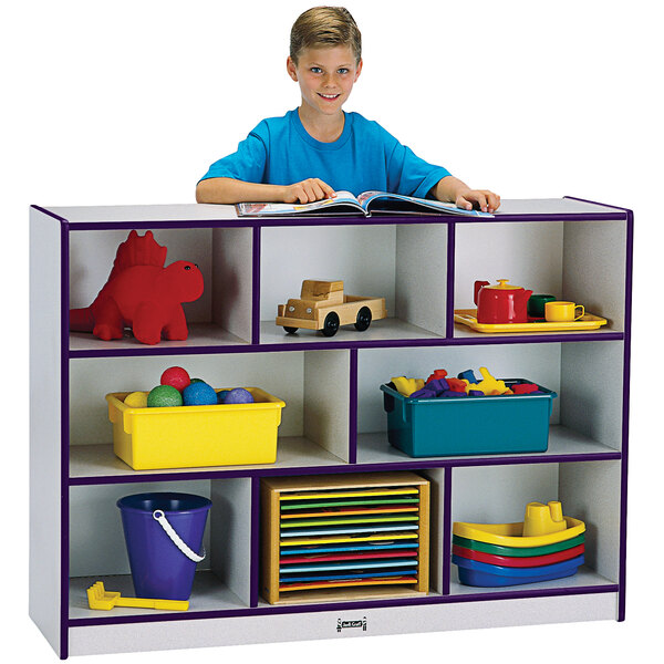 A boy reading a book on a Rainbow Accents purple and gray storage cabinet.