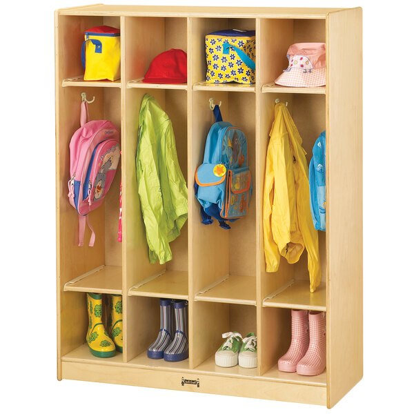 A Jonti-Craft wooden 4-section coat locker with backpacks and coats hanging inside.
