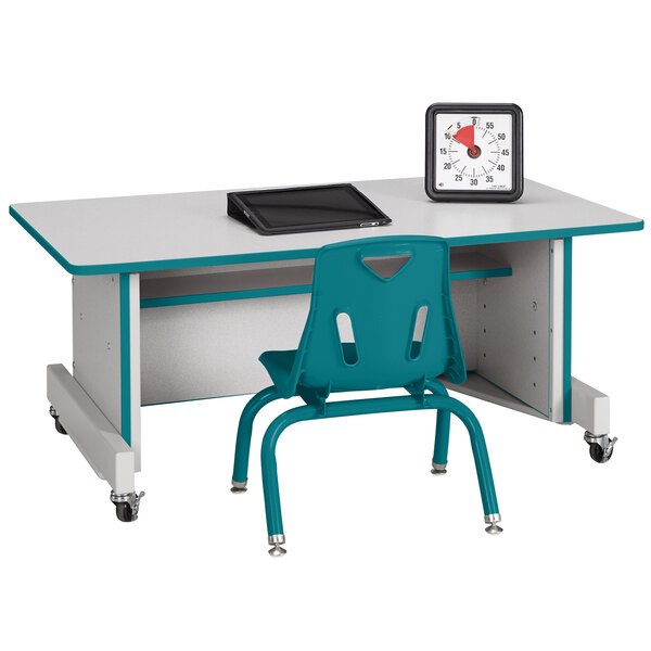 A Rainbow Accents teal computer desk with a chair and a clock on it.