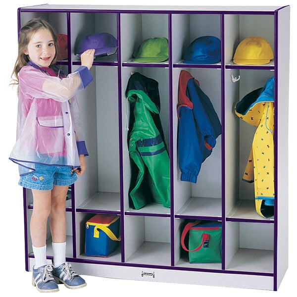 A little girl in a purple raincoat standing next to a Rainbow Accents purple coat locker.