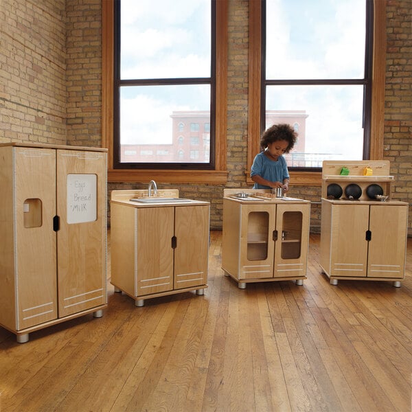 A child playing in a Jonti-Craft play kitchen set.