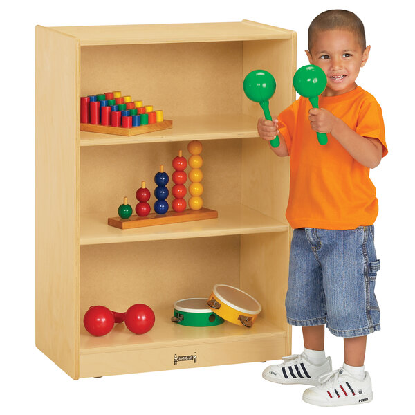 A young boy playing with green and yellow toys on a Jonti-Craft wood storage cabinet.