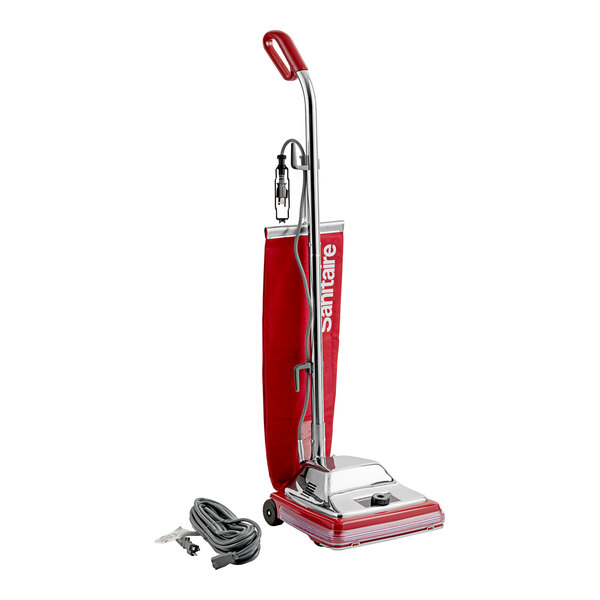 A red and white Sanitaire TRADITION upright vacuum cleaner with a cord and handle.