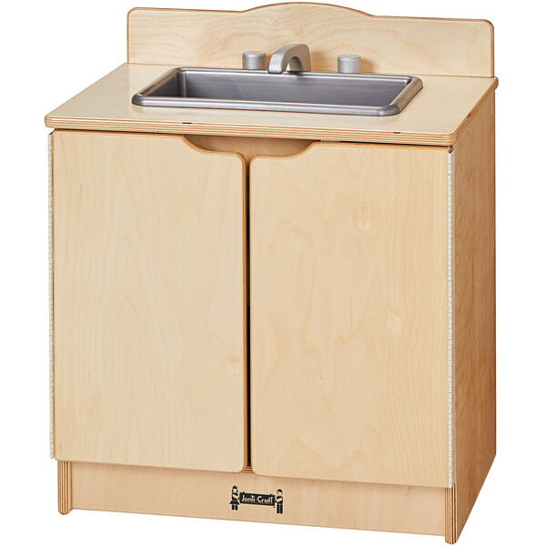 A Jonti-Craft wooden toddler kitchen sink with a silver faucet over a cabinet.