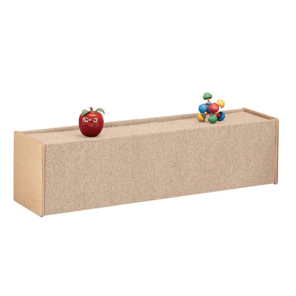 A Jonti-Craft large wooden cruiser box with carpet on top and a red apple on it.