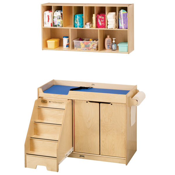 A Jonti-Craft wooden baby changing table with a blue wall-mount shelf.