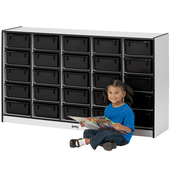 a girl sitting on the floor reading a book