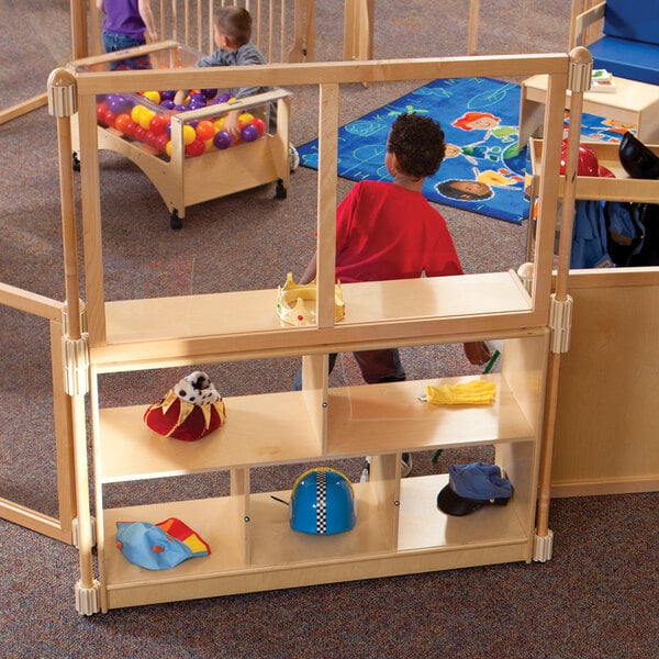 A group of children playing in a classroom with a KYDZ Suite acrylic upper deck divider.