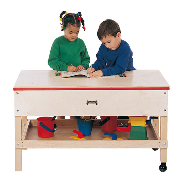 Two children playing with toys at a Jonti-Craft sensory table.