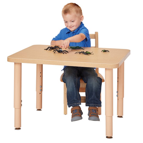 A child sitting at a Jonti-Craft rectangular table with toy bugs.