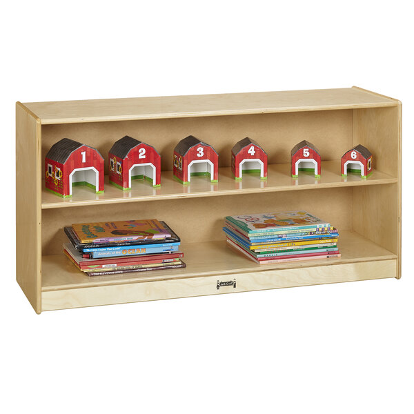 A Jonti-Craft wooden shelf with toy houses and books.