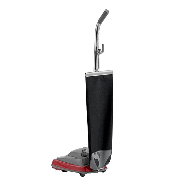 A red and black Sanitaire TRADITION upright vacuum cleaner with a black handle.