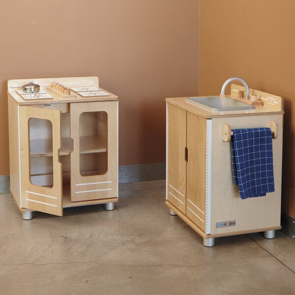 A Jonti-Craft play kitchen sink in a wooden cabinet with a door open.