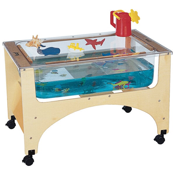 A Jonti-Craft mobile wooden sensory table with see-thru sides filled with water and toys.