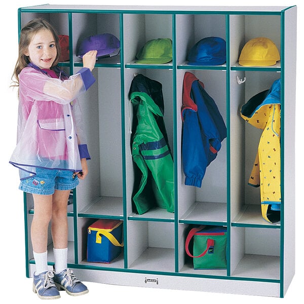 A young girl wearing a teal raincoat standing next to a Rainbow Accents teal and gray coat locker.