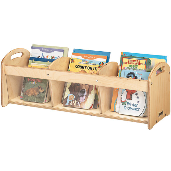 A Jonti-Craft wooden book rack with three see-through sections filled with books.