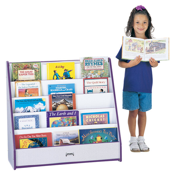 A young girl holding a book on a purple and white Rainbow Accents book rack.