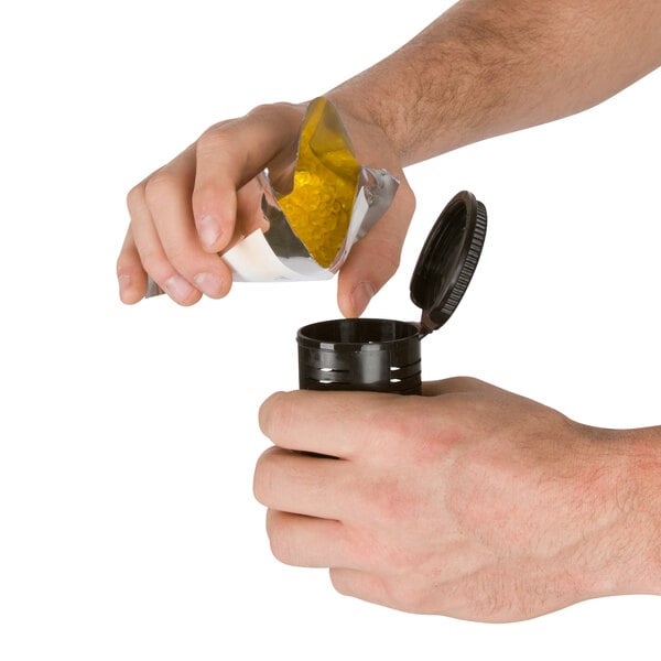 A person using the blue XPOWER Freshen Aire air mover to open a bag of yellow substance.