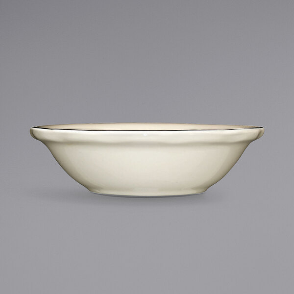 A white stoneware fruit bowl with a black rim.