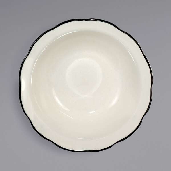 A white stoneware fruit bowl with a black rim.
