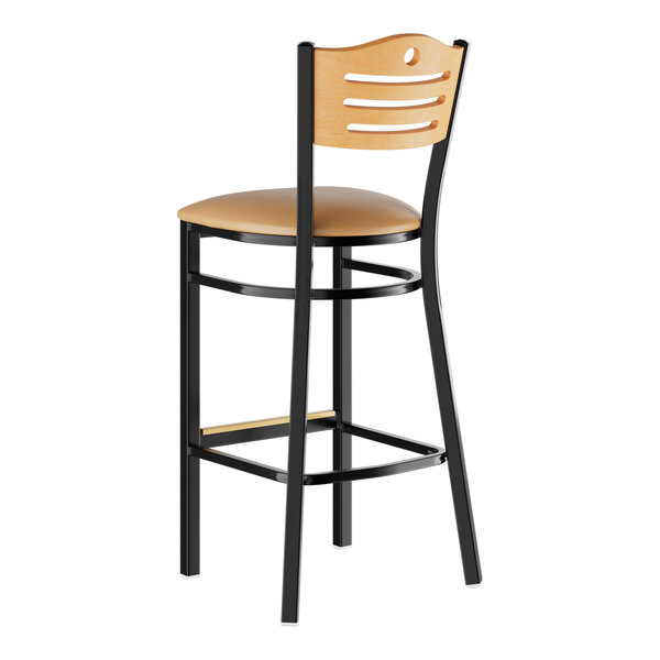 A Lancaster Table & Seating black bar stool with a light brown cushioned seat and natural wood back.