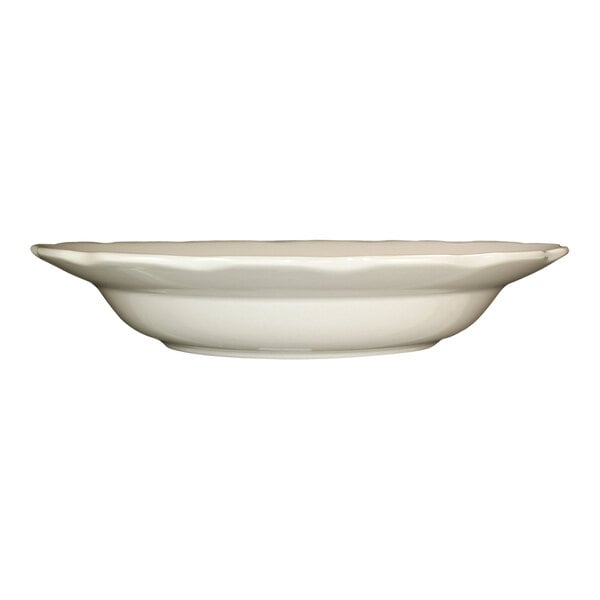 A white stoneware pasta bowl with a scalloped edge.