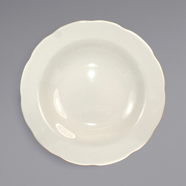 An ivory stoneware bowl with a scalloped rim.