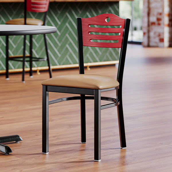 A Lancaster Table & Seating side chair with a brown vinyl seat and a black frame on a table in a restaurant dining area.