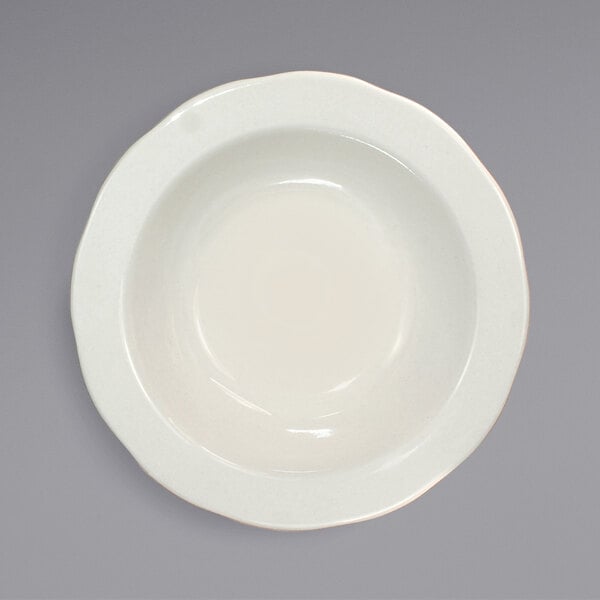 An International Tableware ivory stoneware bowl with a scalloped rim.