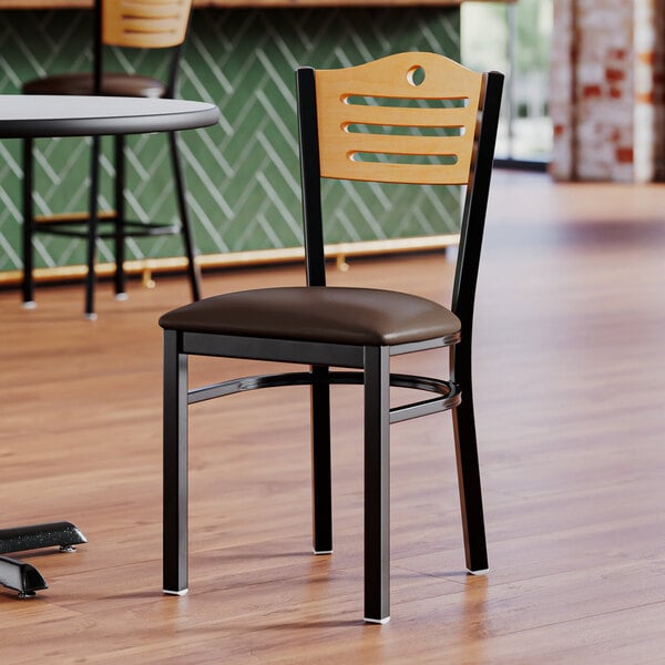 A Lancaster Table & Seating side chair with a natural wood back and dark brown vinyl seat.