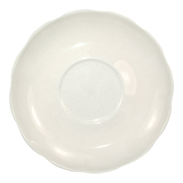An ivory stoneware saucer with a scalloped edge.